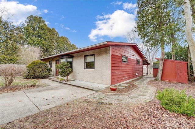 view of home's exterior with a patio area and brick siding