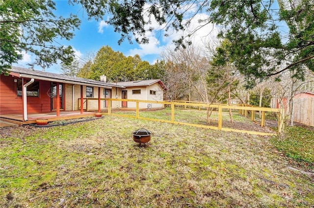 view of yard featuring an outdoor fire pit and fence