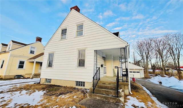 view of front of house featuring a garage and an outbuilding