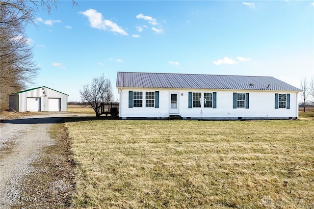 view of front of home featuring an outbuilding, metal roof, a garage, crawl space, and a front lawn