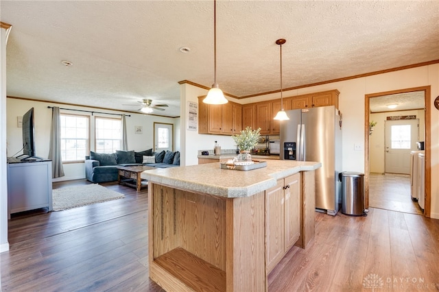 kitchen featuring light countertops, a kitchen island, light wood finished floors, and stainless steel fridge with ice dispenser