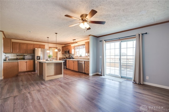 kitchen featuring ornamental molding, stainless steel appliances, dark wood-type flooring, and plenty of natural light