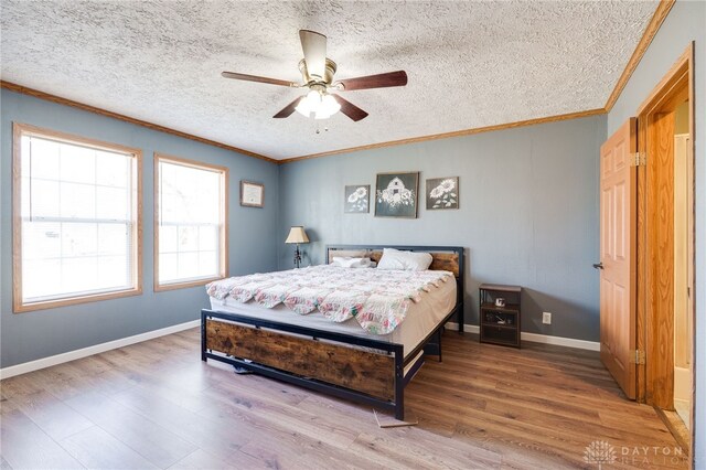 bedroom featuring ornamental molding, baseboards, and wood finished floors