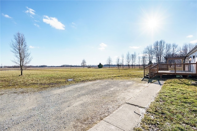 view of yard featuring a rural view and a wooden deck