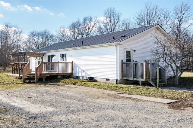 back of property featuring a deck, metal roof, and crawl space