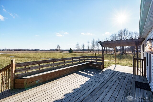 wooden deck featuring a rural view and a lawn