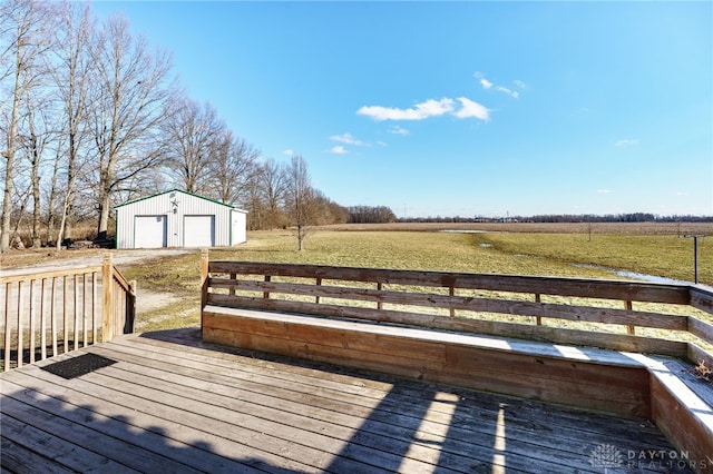 deck with a garage, a rural view, and an outdoor structure