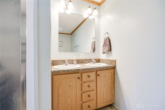 full bath featuring double vanity, crown molding, and a sink