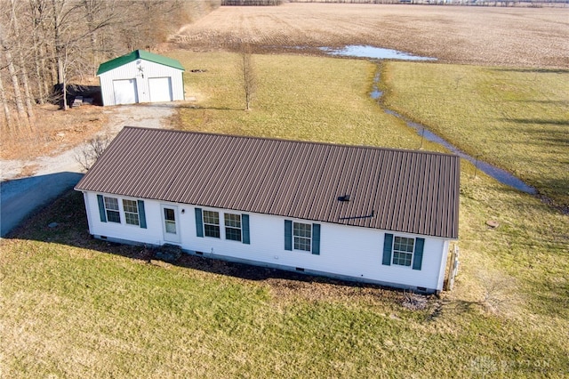 view of front facade with an outbuilding, metal roof, crawl space, a storage unit, and a front yard