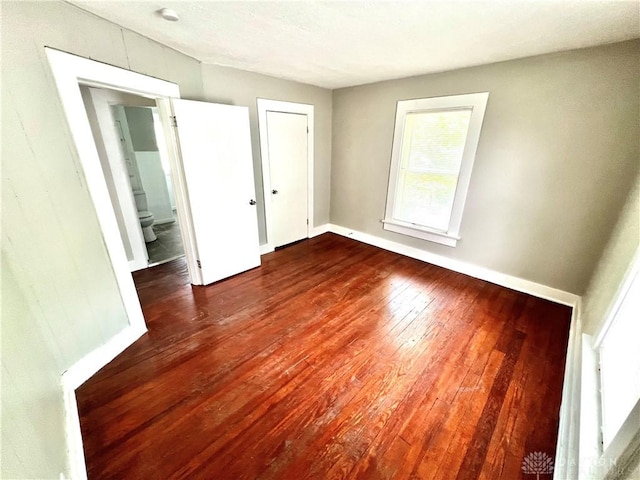 unfurnished bedroom with wood-type flooring and baseboards