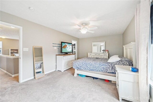 bedroom with a ceiling fan, light colored carpet, and baseboards