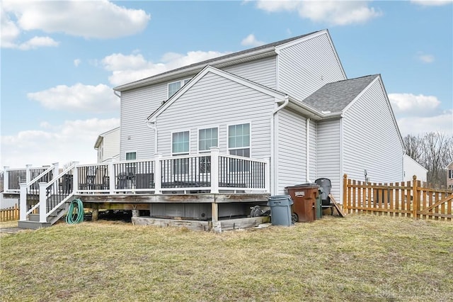 rear view of property featuring fence private yard, a lawn, and a wooden deck