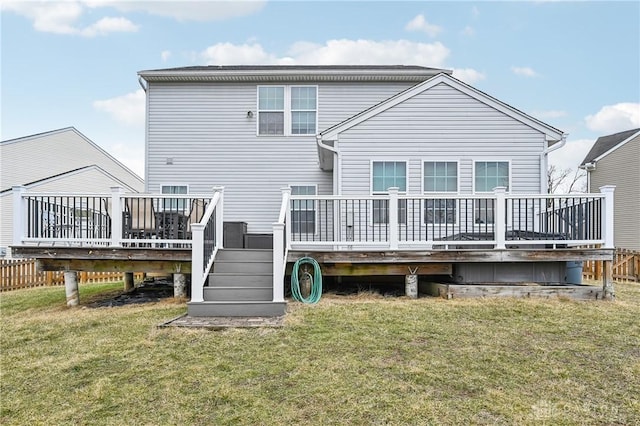 back of property featuring a wooden deck and a yard