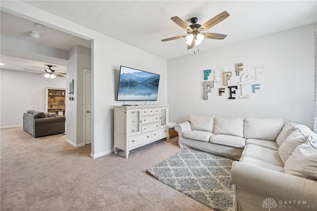 carpeted living room with ceiling fan and baseboards