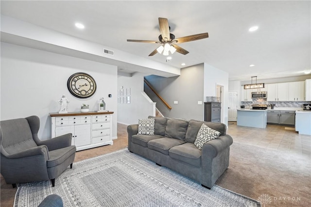 living area with light carpet, stairs, visible vents, and recessed lighting