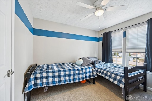 bedroom featuring carpet, ceiling fan, and a textured ceiling