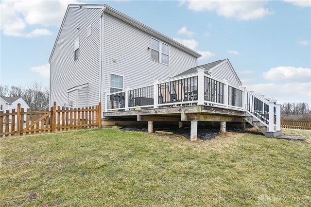 rear view of house with a fenced backyard, a lawn, and a wooden deck