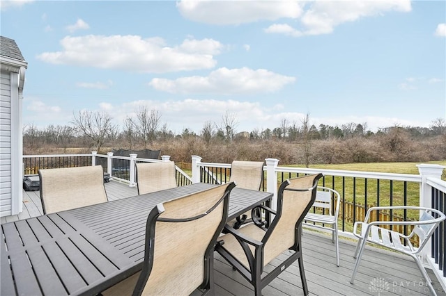 wooden terrace with a yard and outdoor dining area