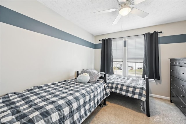 bedroom with carpet floors, ceiling fan, baseboards, and a textured ceiling