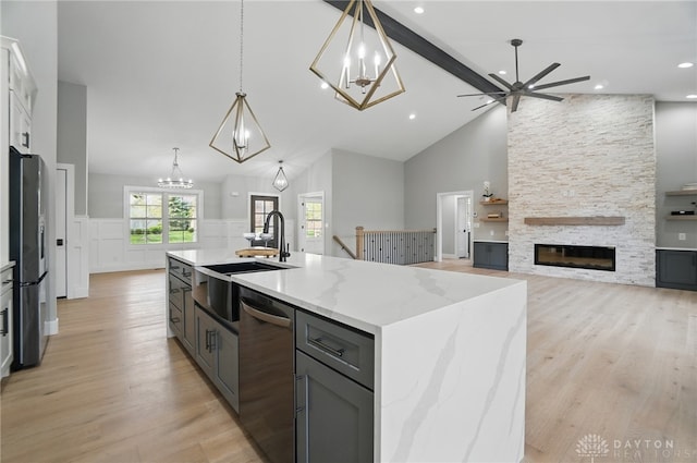 6976 Rosecliff Pl, Dayton, OH 45459 - kitchen featuring appliances with stainless steel finishes, a sink, a fireplace, light wood finished floors, and ceiling fan