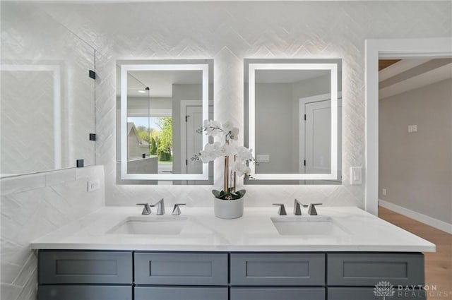 6976 Rosecliff Pl, Dayton, OH 45459 - bathroom with double vanity, wood finished floors, backsplash, and tile walls