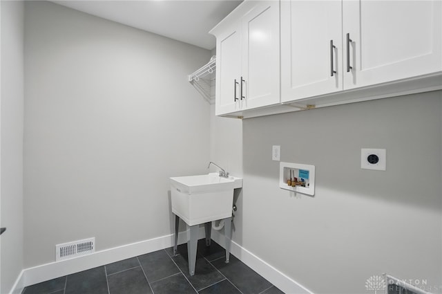 6976 Rosecliff Pl, Dayton, OH 45459 - washroom featuring cabinet space, electric dryer hookup, washer hookup, baseboards, and dark tile patterned floors