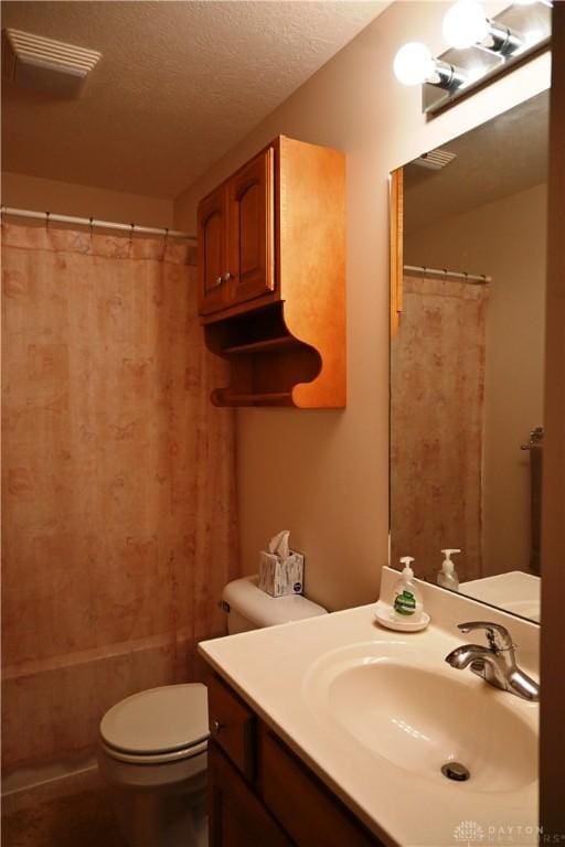 bathroom featuring a textured ceiling, toilet, visible vents, and vanity