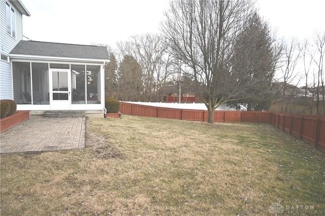 view of yard with a patio area, a fenced backyard, and a sunroom