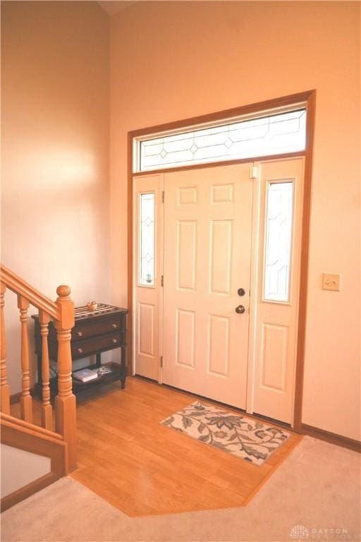 entrance foyer with stairs and wood finished floors