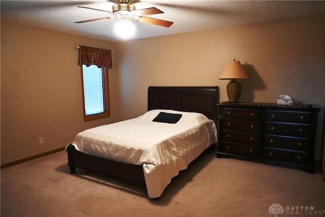 carpeted bedroom with ceiling fan and baseboards