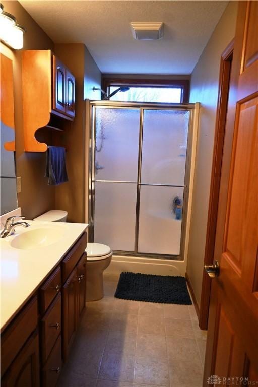 full bath featuring a stall shower, visible vents, toilet, tile patterned flooring, and vanity