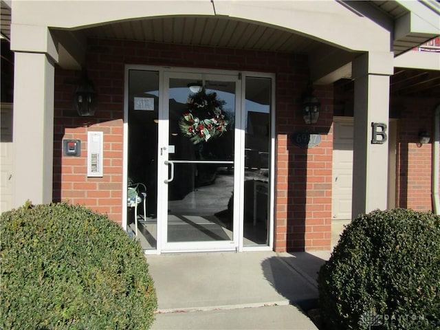 doorway to property with brick siding