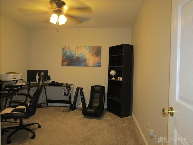 home office featuring carpet floors, ceiling fan, and baseboards