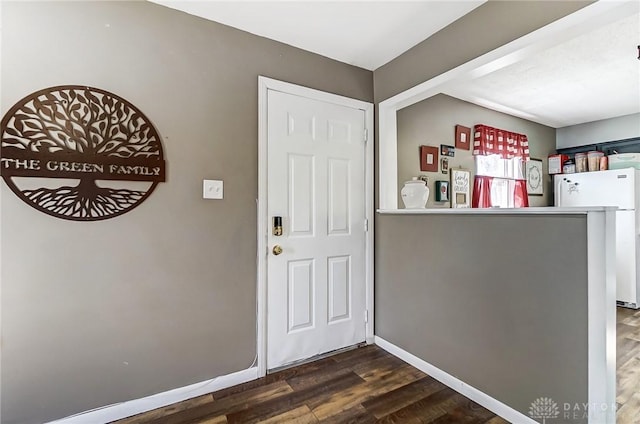 entrance foyer featuring dark wood finished floors and baseboards