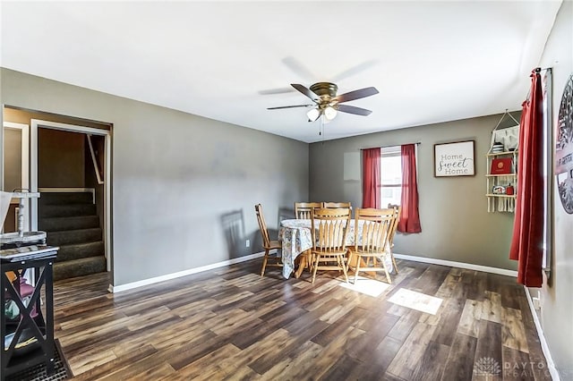 dining room with dark wood-style floors, ceiling fan, stairway, and baseboards