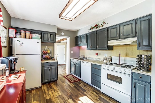 kitchen with under cabinet range hood, white appliances, light countertops, dark wood-style floors, and tasteful backsplash