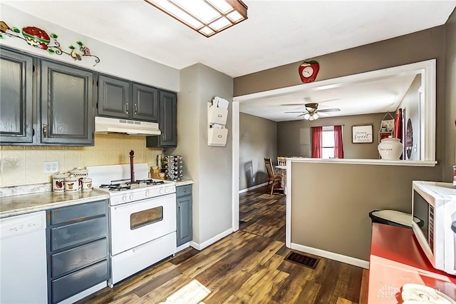 kitchen with light countertops, white appliances, decorative backsplash, and under cabinet range hood