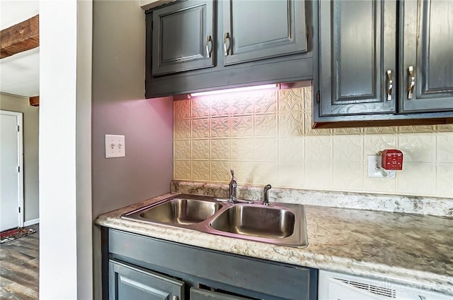 kitchen featuring tasteful backsplash, light countertops, a sink, and wood finished floors