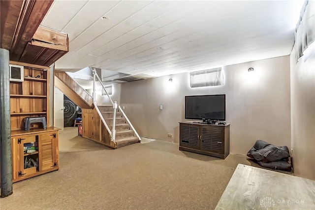 finished below grade area featuring wooden ceiling, stairway, and carpet flooring