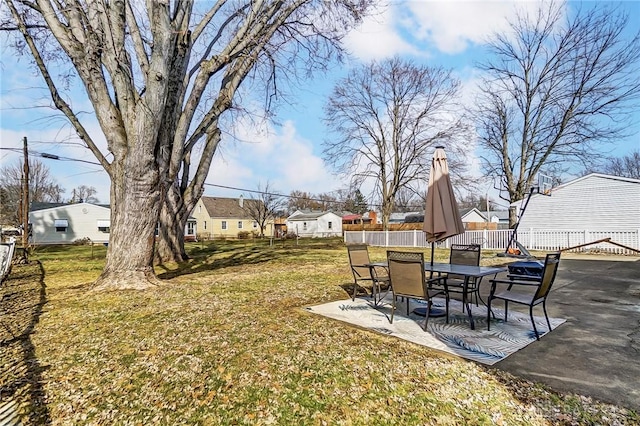 view of yard with a patio, fence, and a residential view