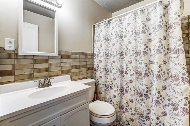 full bathroom with wainscoting, toilet, curtained shower, vanity, and tile walls