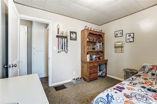 bedroom with baseboards, visible vents, and dark carpet