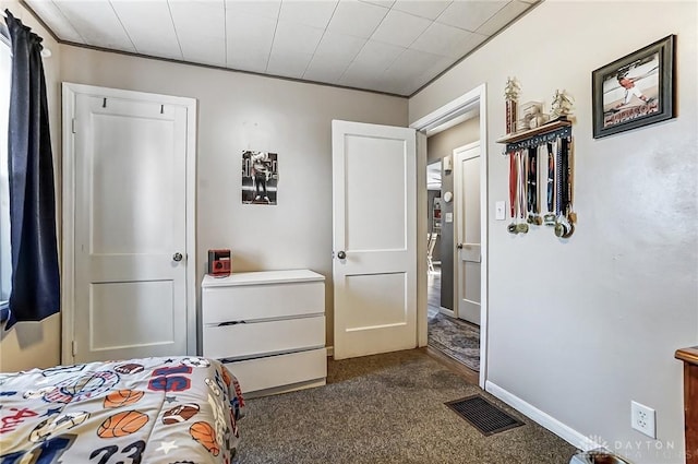 bedroom featuring baseboards, visible vents, and dark colored carpet