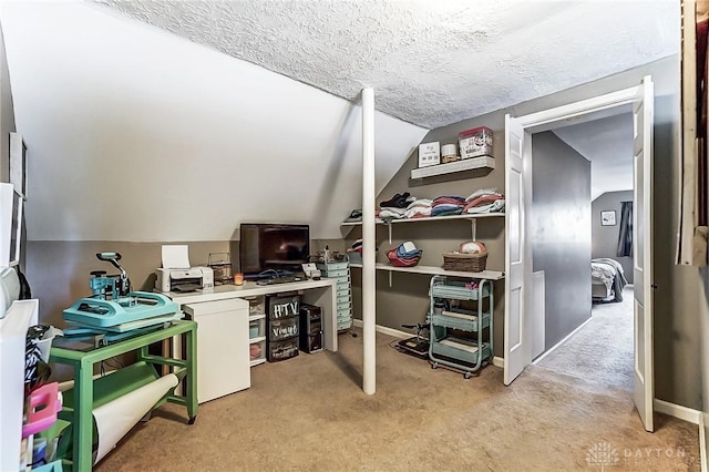 office area with a textured ceiling, baseboards, lofted ceiling, and light colored carpet