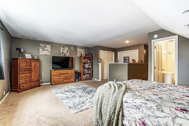 bedroom with ensuite bath, carpet flooring, and baseboards