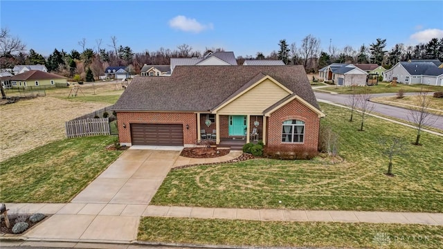 view of front of property featuring brick siding, an attached garage, a front yard, fence, and driveway