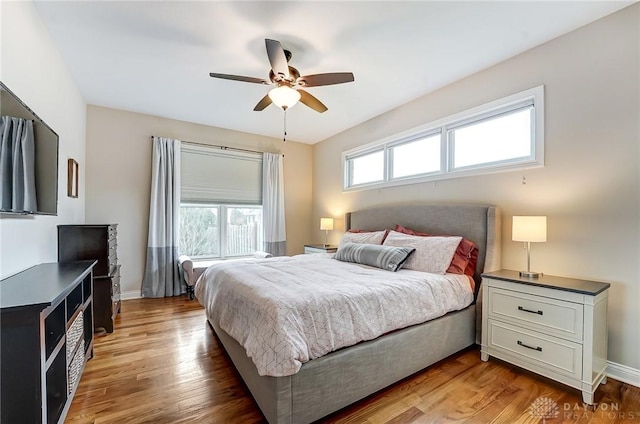 bedroom with light wood-style flooring, multiple windows, and baseboards