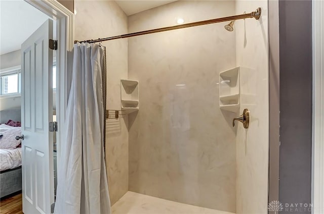 ensuite bathroom featuring curtained shower and connected bathroom