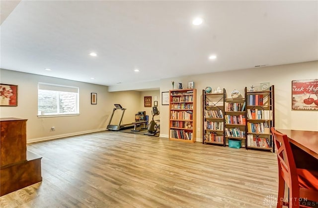 exercise room with baseboards, wood finished floors, and recessed lighting