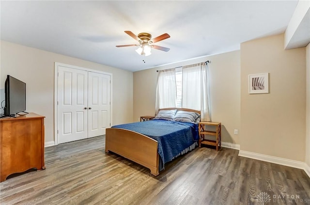 bedroom featuring ceiling fan, a closet, baseboards, and wood finished floors